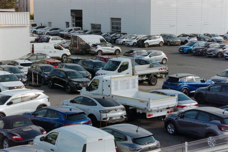A row of cars with price tags at a dealership lot