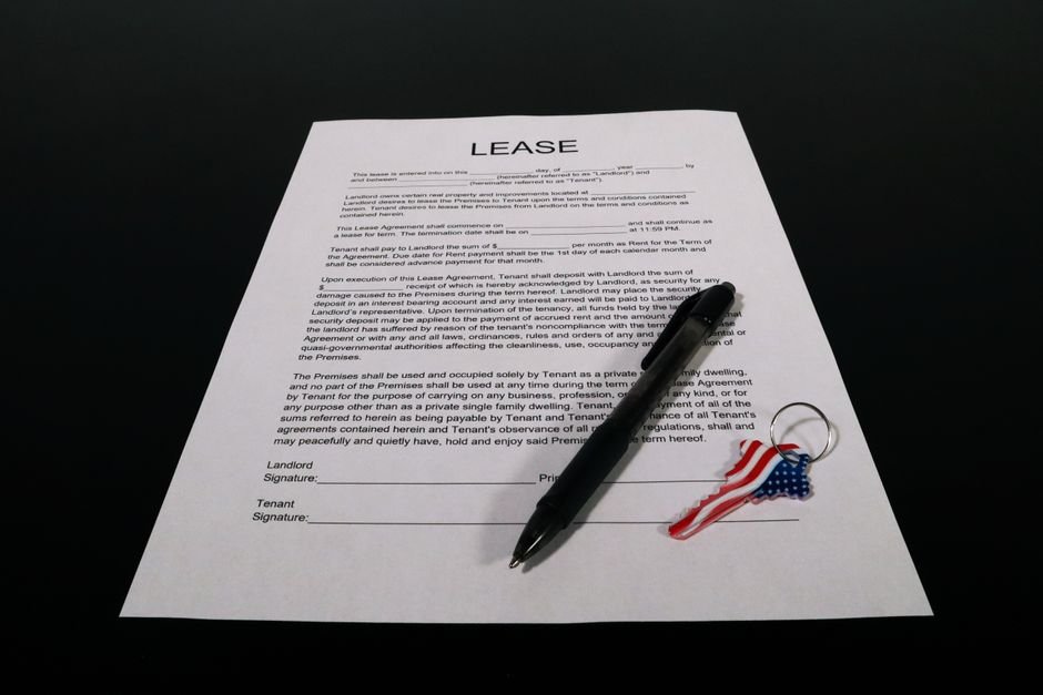 A set of car keys resting on printed vehicle paperwork on a table