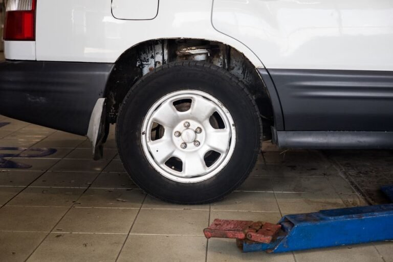 A car raised on an alignment rack in an auto shop with alignment equipment attached to the wheels