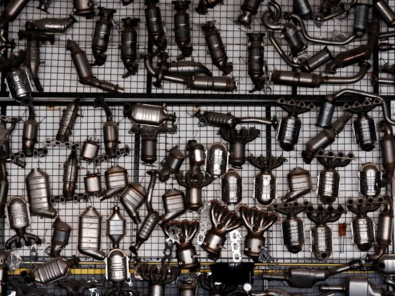 A catalytic converter and exhaust piping visible underneath a car on a lift
