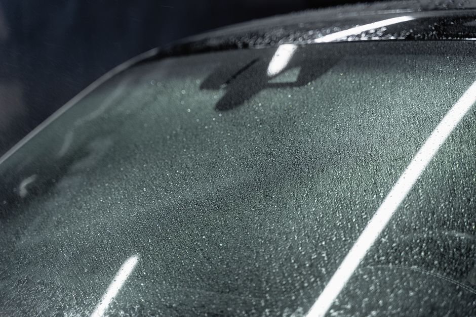 Close-up of a small chip in a car's windshield glass