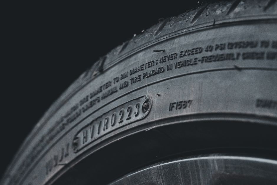 Close-up of a tire sidewall showing the load index and speed rating code stamped into the rubber
