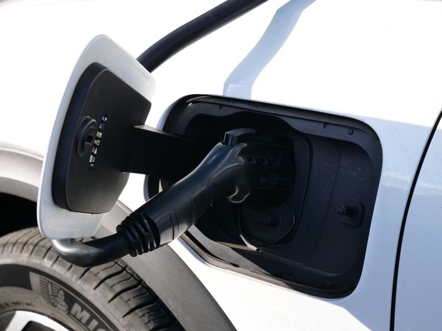 Close-up of an electric vehicle charging connector plugged into a car's charge port