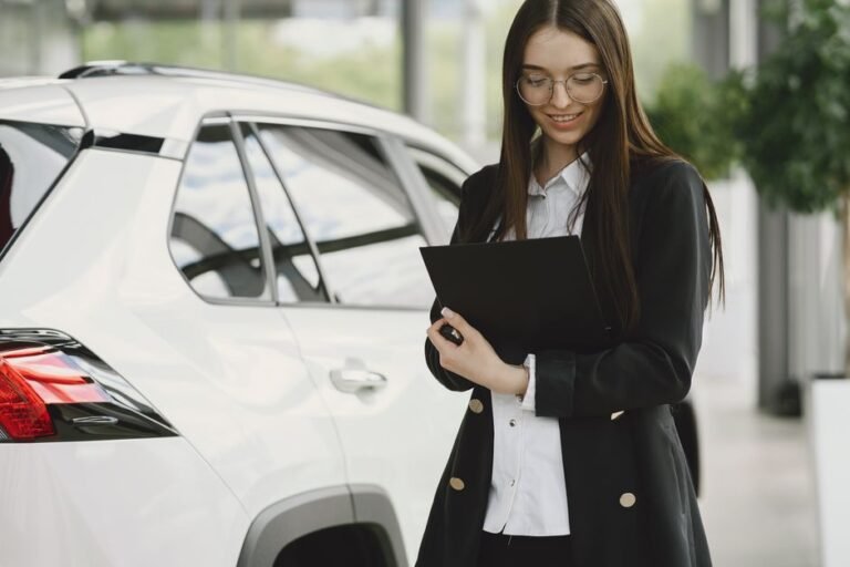 A warranty document on a clipboard next to a parked electric car