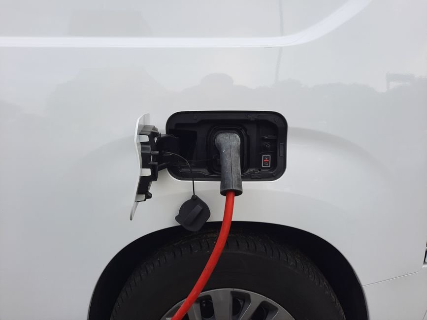 A fuel economy and environment label on the side window of a new electric car at a dealership