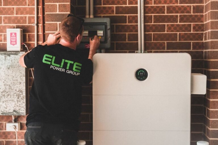 A home battery storage unit mounted on a garage wall next to an EV charger