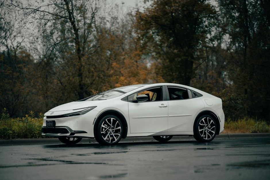 A plug-in hybrid car and a full electric car parked side by side in a driveway