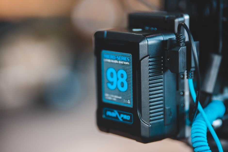 A cordless power tool battery pack seated in its charging dock on a workbench