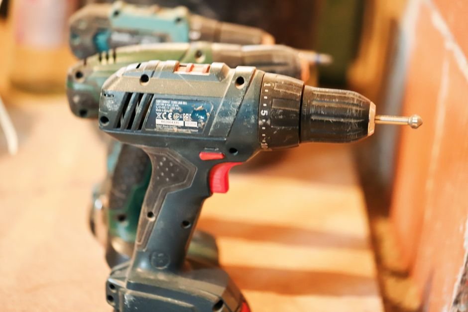 Cordless power tool batteries lined up on a shelf in a storage closet
