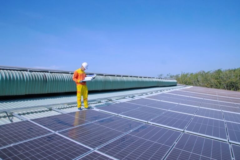 A solar installer reviewing a clipboard while standing on a residential roof