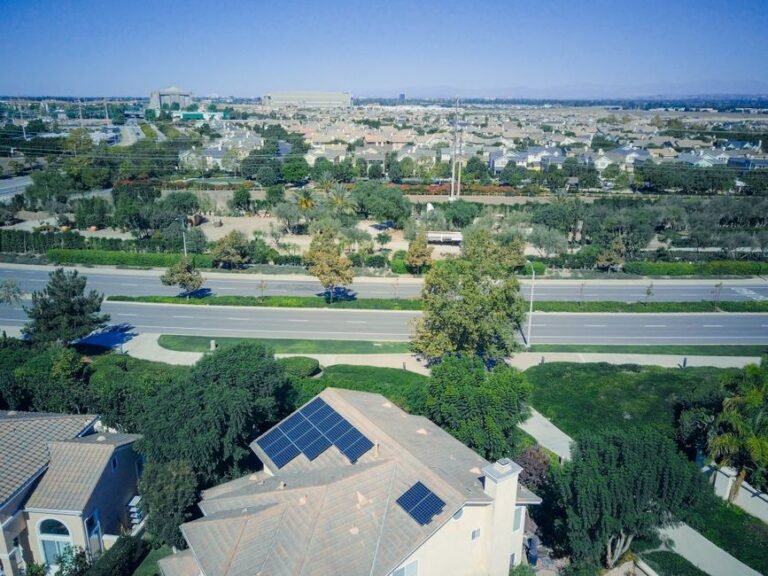 Aerial view of a suburban house with solar panels on two sides of a pitched roof