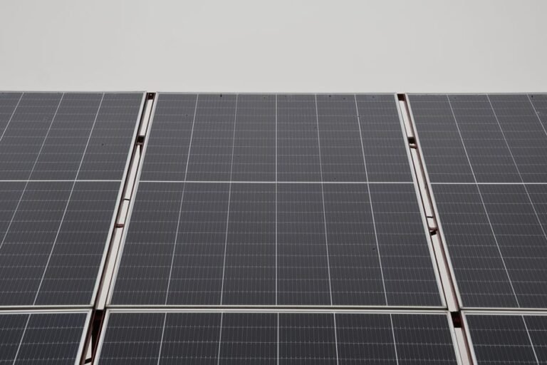 Weathered solar panels on a roof with light dust and minor discoloration on the frames