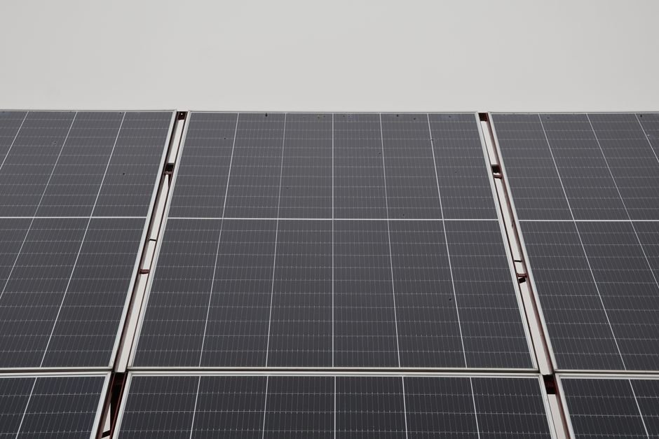 Weathered solar panels on a roof with light dust and minor discoloration on the frames